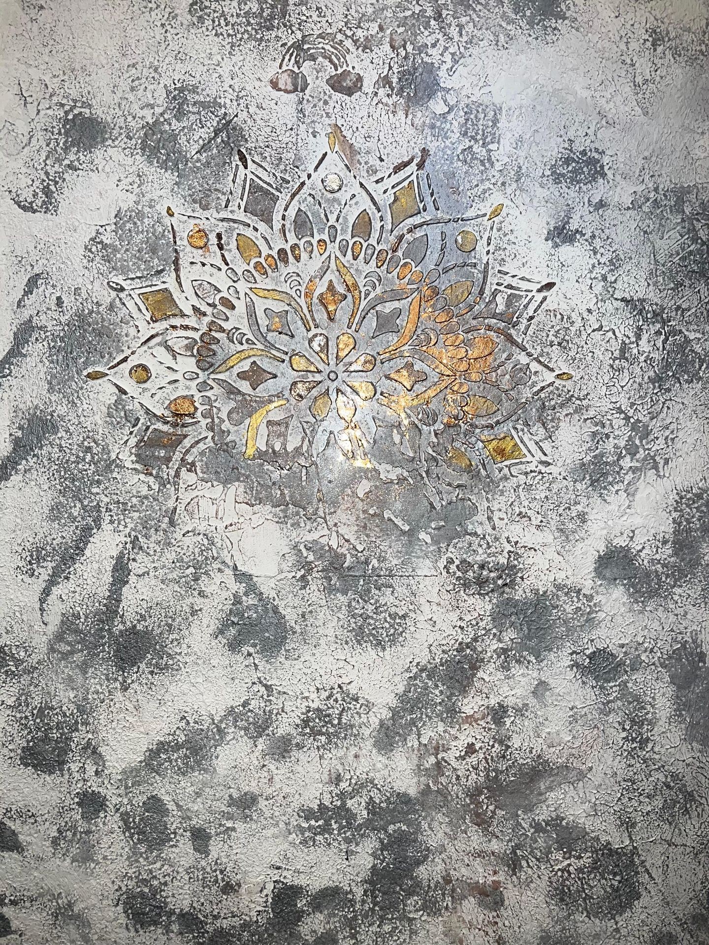 Intricate floral mandala design on a textured, weathered wall surface.